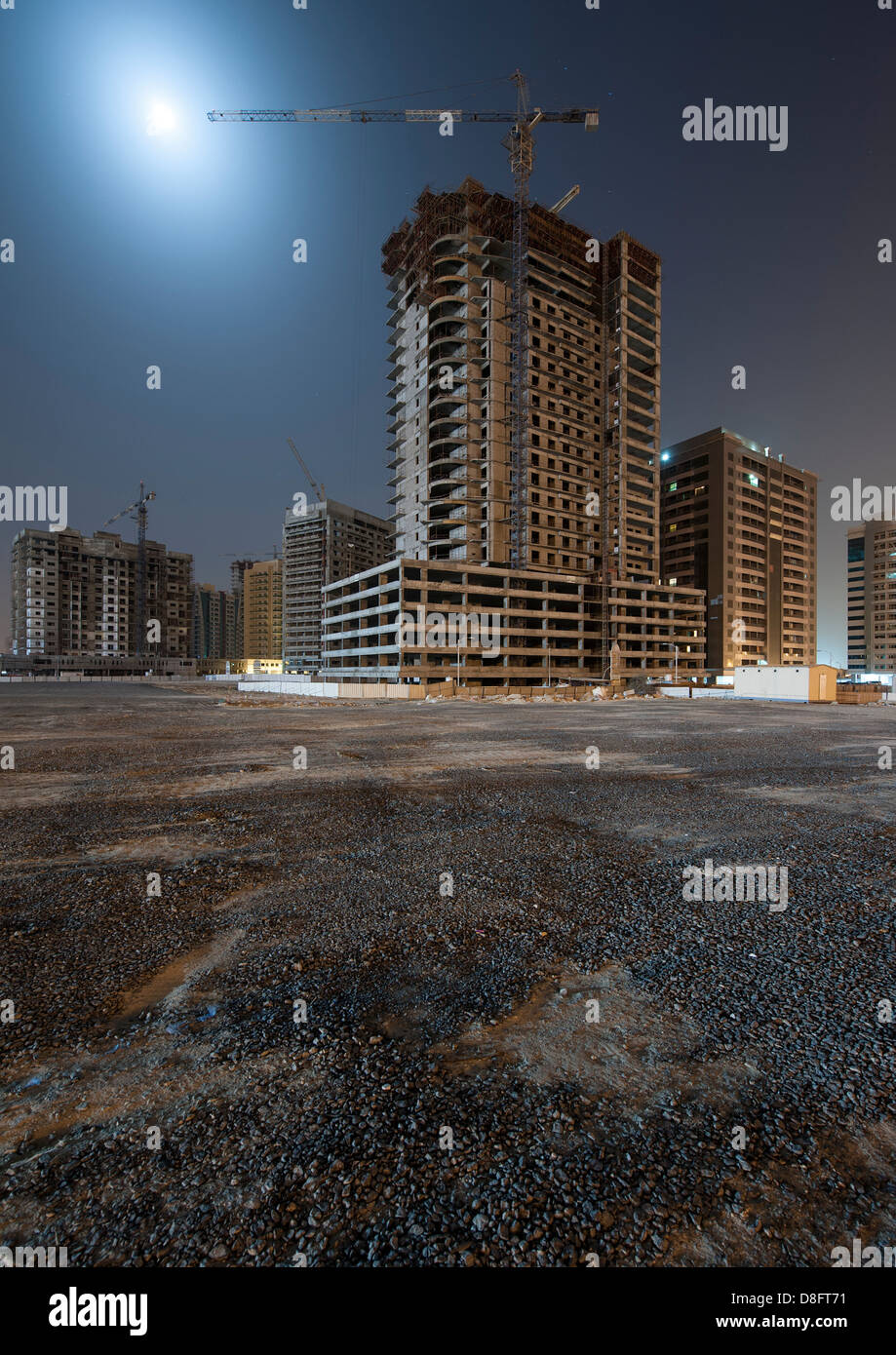 Siti di costruzione di grattacieli in città sportiva di notte, Dubai, UAE Foto Stock