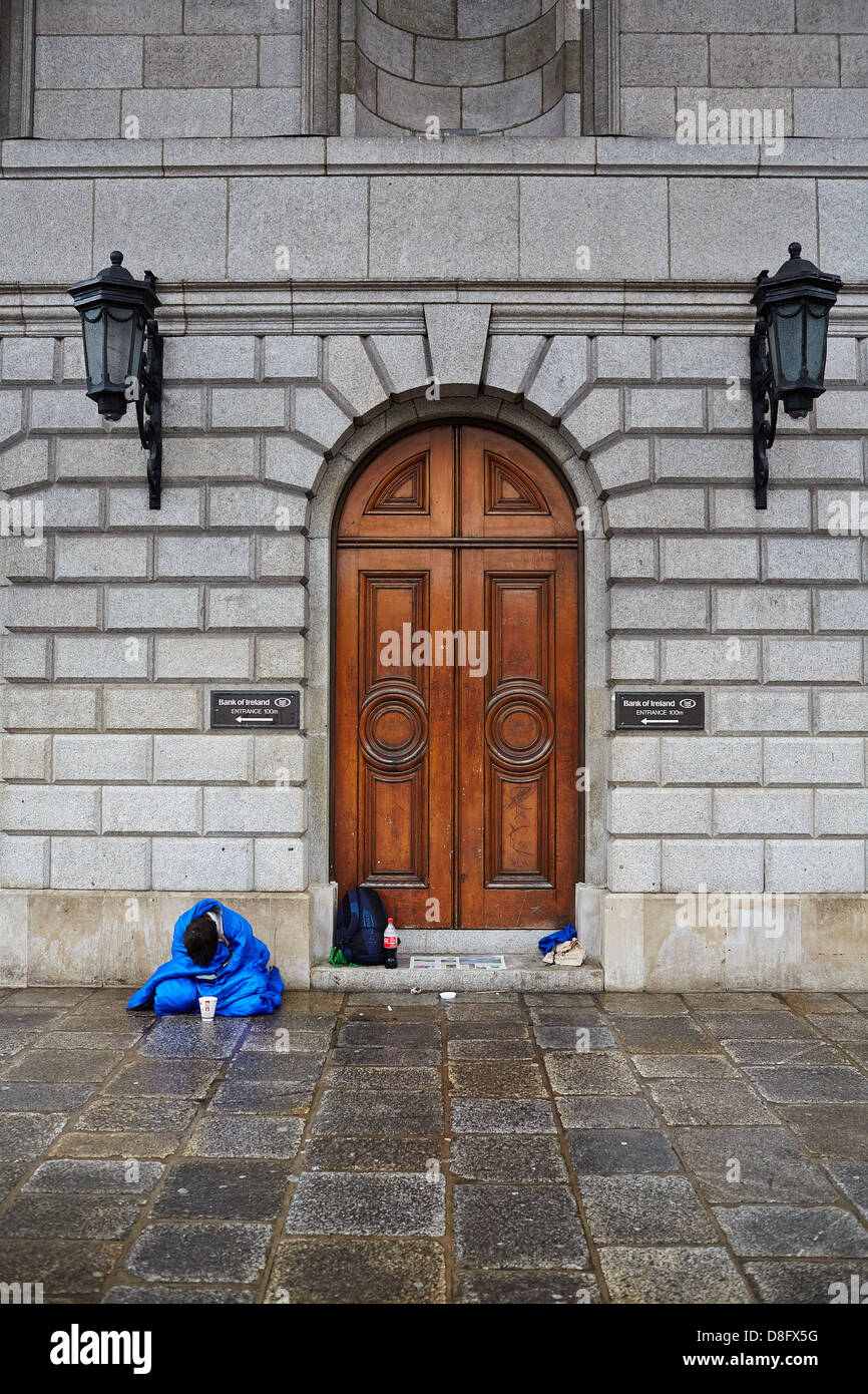 La persona senza dimora avvolto in un sacco a pelo nella zona per lo shopping, Henry Street, il centro della città di Dublino durante una recessione economica Foto Stock