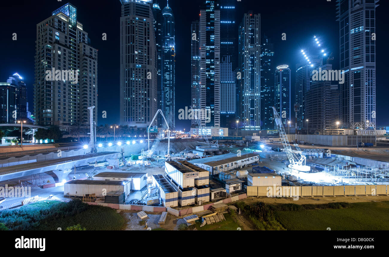 Siti di costruzione illuminando e grattacieli di notte in Marina, Nuova Dubai, UAE Foto Stock