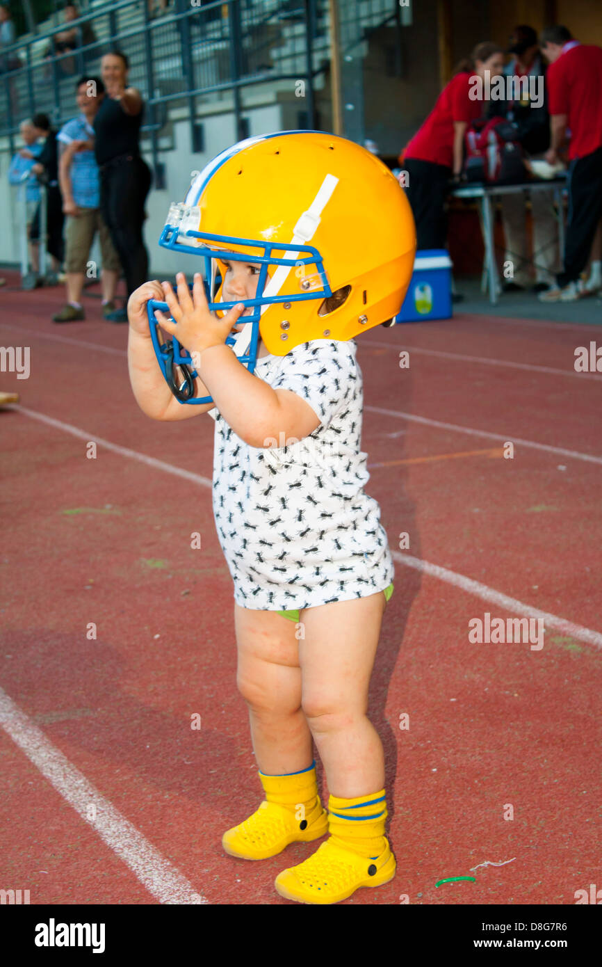 Il bambino sta indossando un casco da football americano Foto stock - Alamy