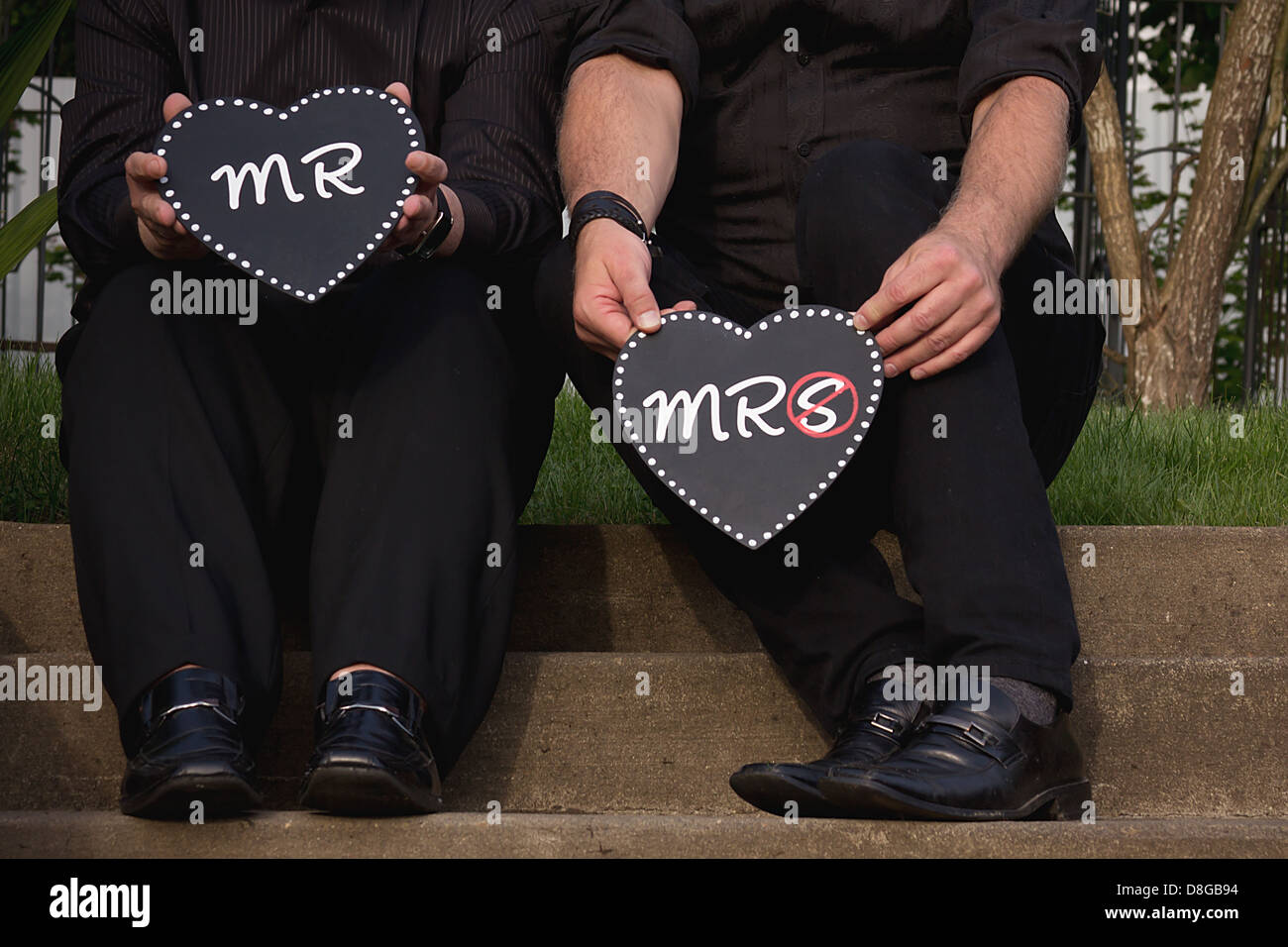 Coppia omosessuale tenendo il signor e la signora a forma di cuore segni. Foto Stock