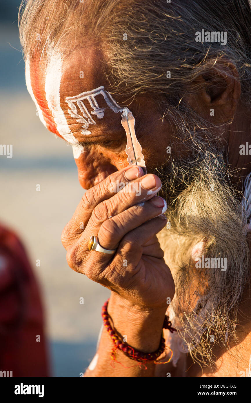 Sadhu dipinto il suo volto con la parola di Dio sulla sua fronte presso il Kumbh Mela, Allahabad, India Foto Stock