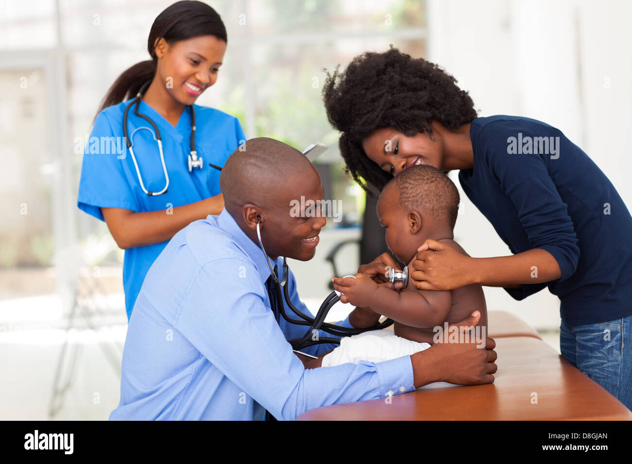 Allegro madre africana e suo figlio nell'ufficio del medico con connettore maschio di tipo medico e infermiere femmina Foto Stock