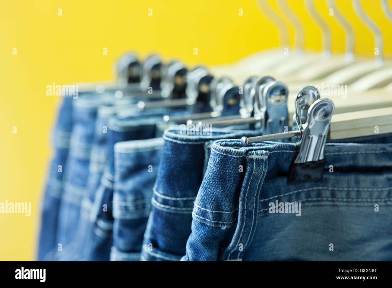 Fila di impiccato blue jeans in un negozio Foto Stock