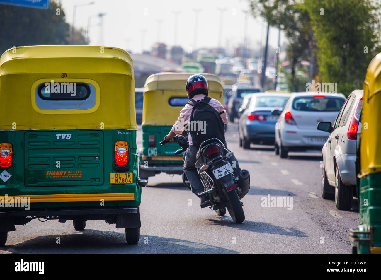 La tessitura in motocicletta attraverso il traffico su una autostrada a Delhi, India Foto Stock