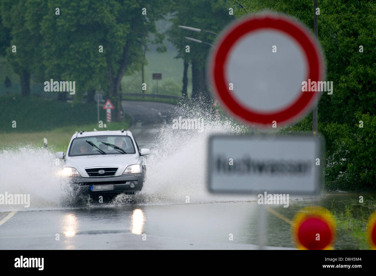 Un auto va lungo una strada allagata vicino Baumbach, Germania, 29 maggio 2013. Fiume Fulda scoppiare le sue banche a causa di piogge ininterrotta. Foto: UWE ZUCCHI Foto Stock