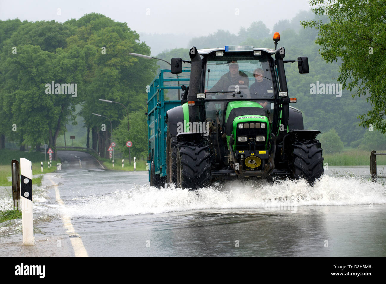 Un trattore passa lungo una strada allagata vicino Baumbach, Germania, 29 maggio 2013. Fiume Fulda scoppiare le sue banche a causa di piogge ininterrotta. Foto: UWE ZUCCHI Foto Stock