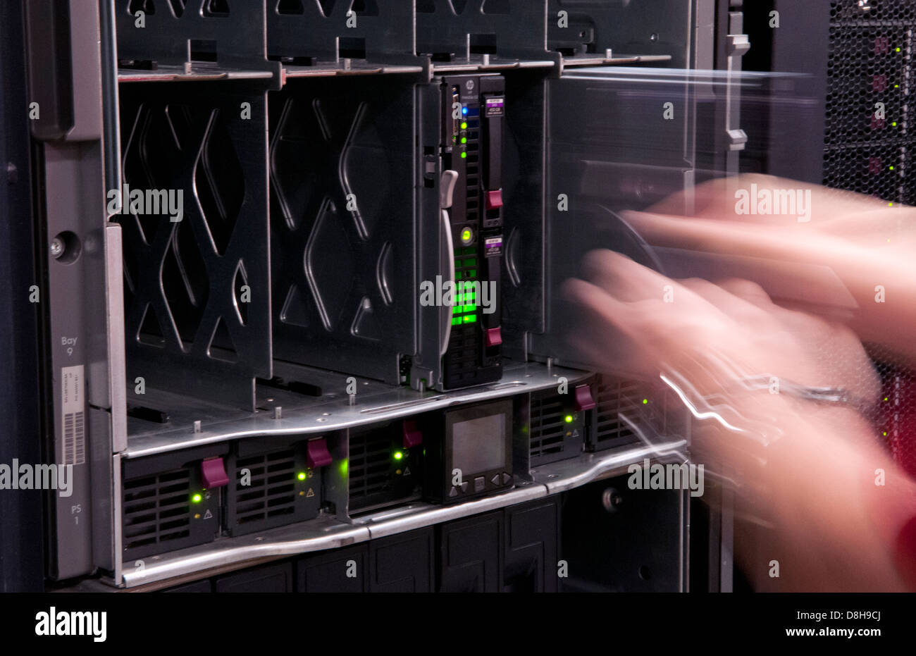 L'uomo l'installazione di lame in grandi impilate computer server nel gruppo IT industry Foto Stock