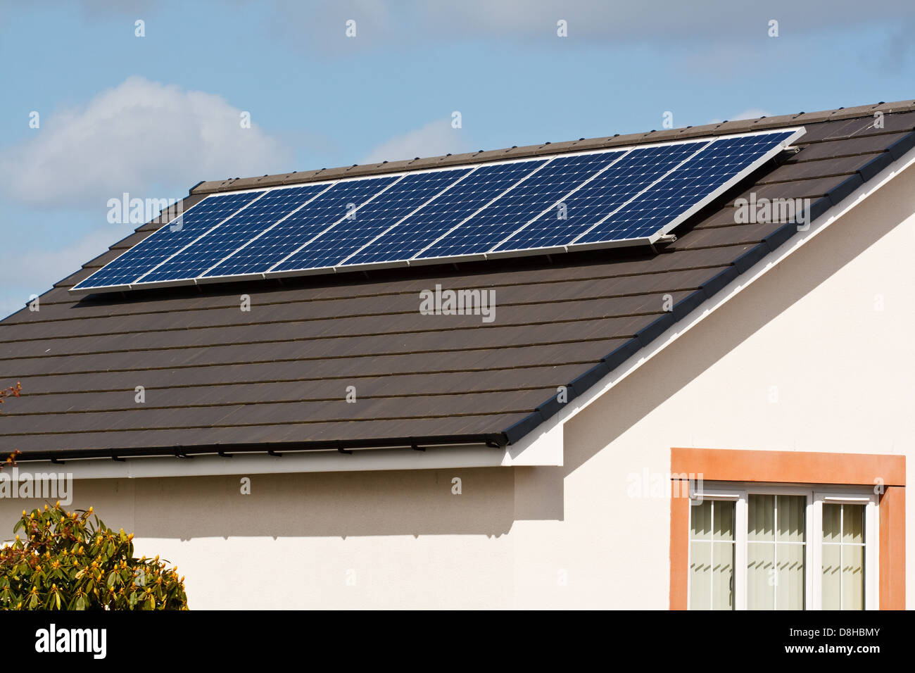 Pannelli solari fotovoltaici montati su un nuovo tetto di tegole di una casa moderna Foto Stock
