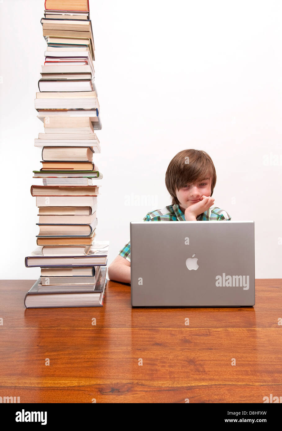 Giovane maschio boy svolgendo compiti usando il computer portatile Foto Stock