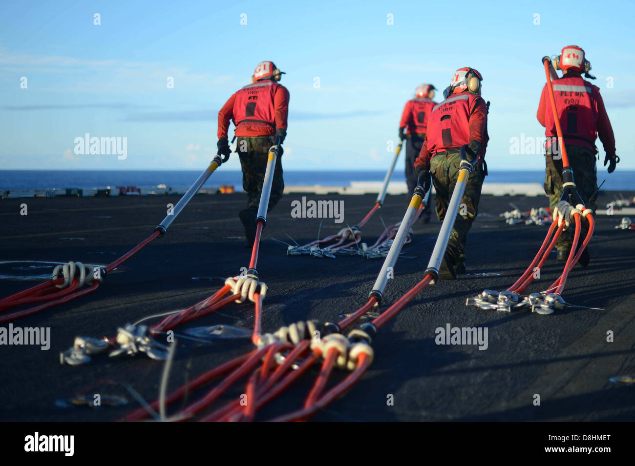 I marinai trascinare cargo poli. Foto Stock