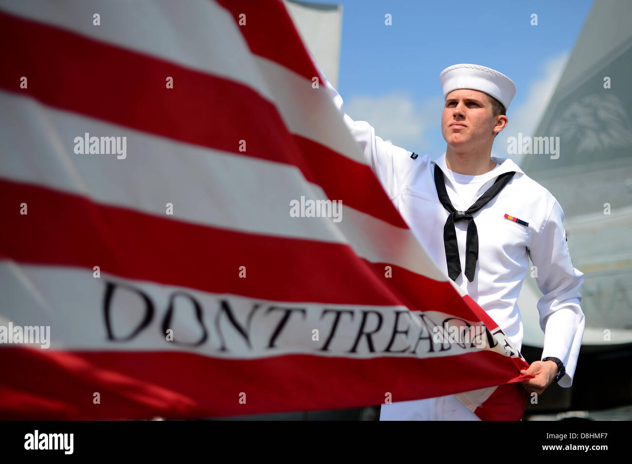 Un marinaio paranco il jack della Marina Militare. Foto Stock