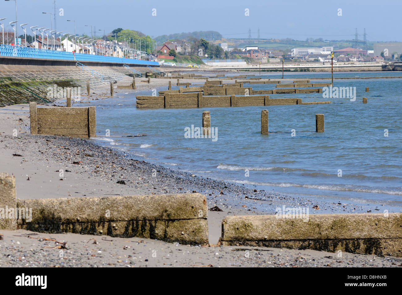 Groynes danneggiato (barriere di erosione costiere) a Carrickfergus, Irlanda del Nord. Foto Stock