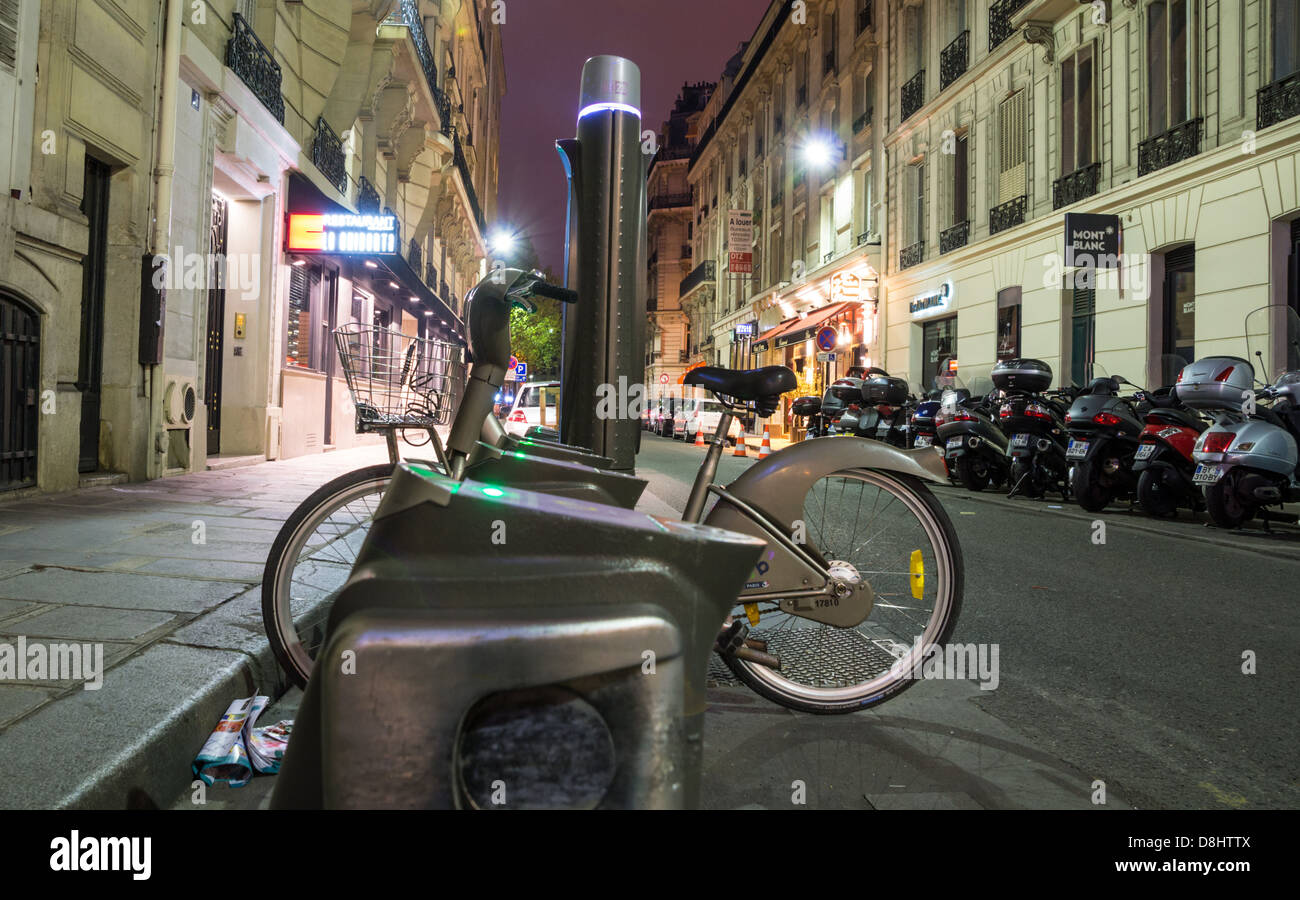 Parigi, Francia. Vélib' (noleggio bici scheme) stazioni a notte. Foto Stock