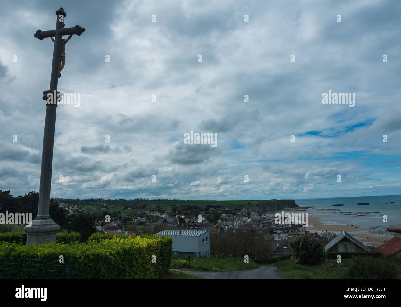 Arromanches, Francia. Una gigantesca croce che domina la città e i resti del 'Mullbery' porto artificiale dalla seconda guerra mondiale. Foto Stock