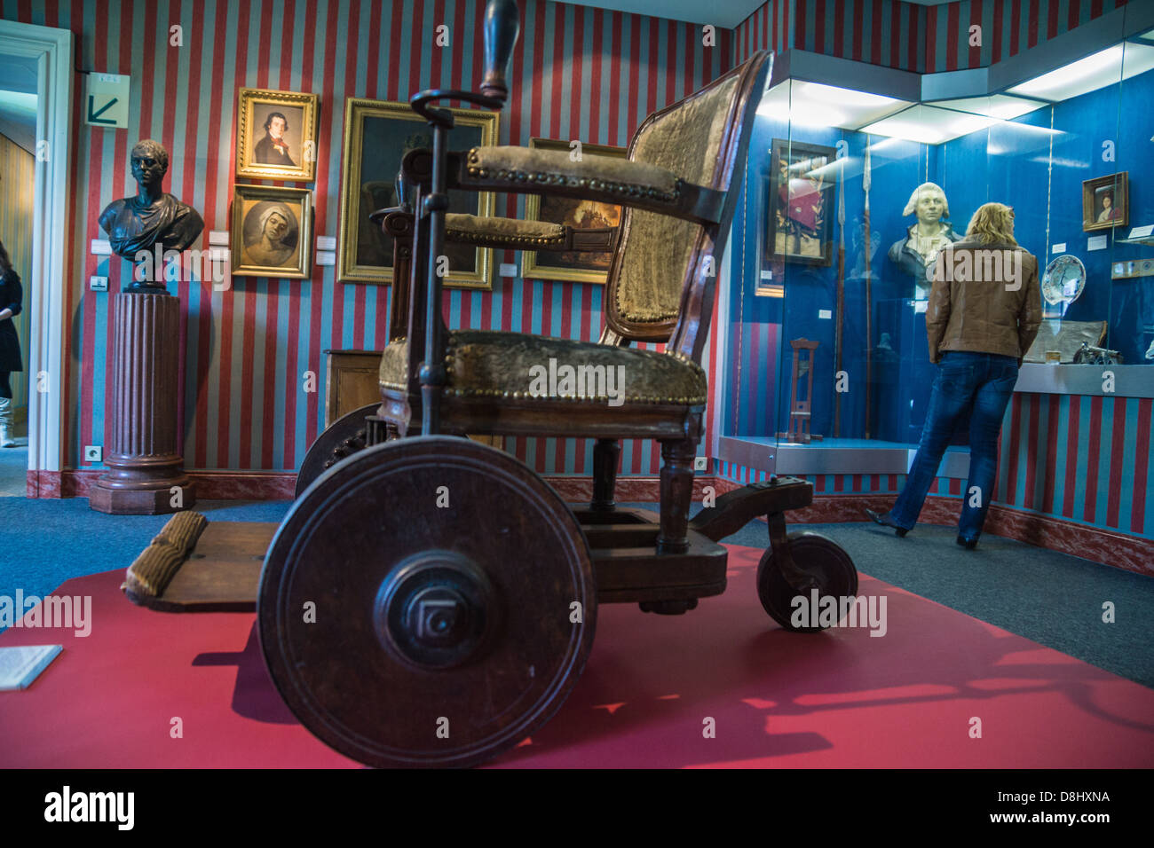 Parigi, Francia. una settecentesca in sedia a rotelle il museo Carnavalet, il museo della storia di Parigi. Dipinti in background. Foto Stock