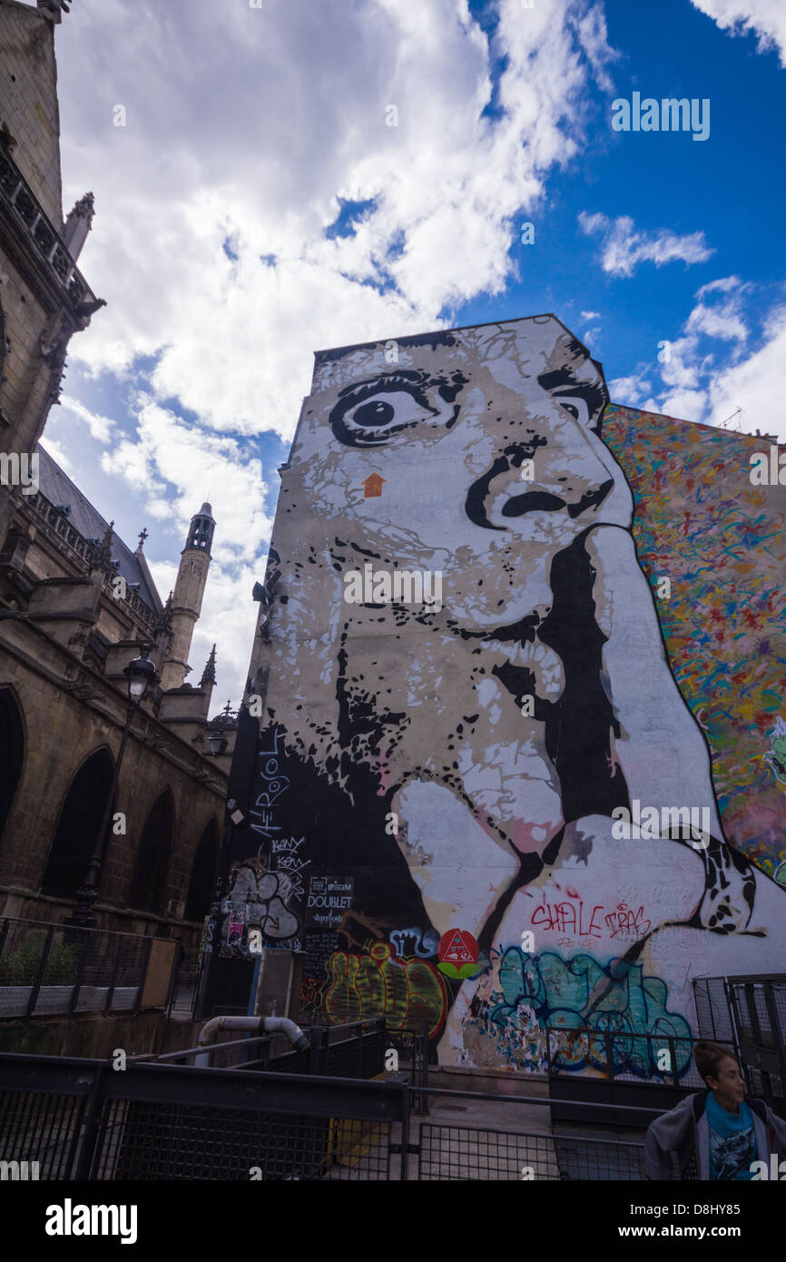 Parigi, Francia. Un uomo passa da un grande dipinto graffiti su un muro vicino al centro Pompidou e la Fontana Stravinsky Foto Stock