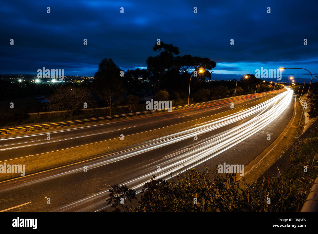 Sentieri di luce dalle vetture di passato di spazzamento Foto Stock