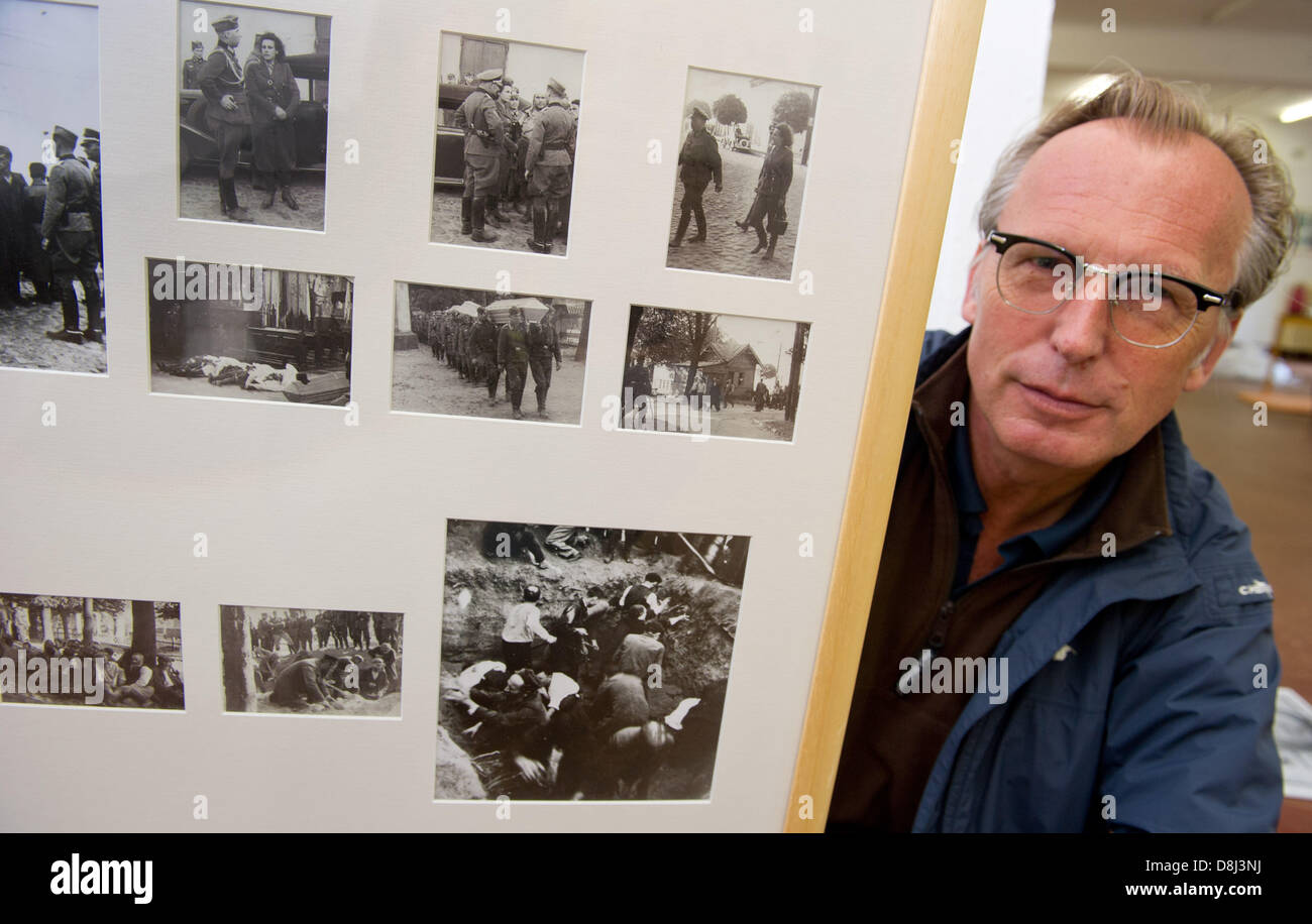 Curatore Pietro Reichelt pone accanto a un consiglio di amministrazione con una raccolta di foto del massacro di Konskie/Polonia presso la mostra speciale 'Leni Riefenstahl' presso il Centro di documentazione a prora, Germania, 29 maggio 2013. Circa 300 presenta dal controverso regista e fotografo, Leni Riefenstahl (1902-2003) sono mostrati in occasione della mostra che si apre il 30 maggio. Foto: Stefan Sauer Foto Stock