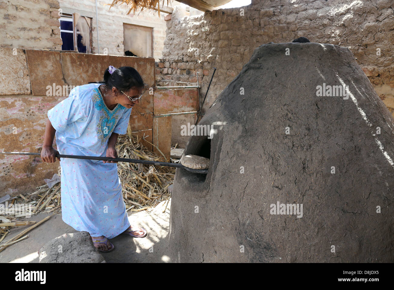 Donna egiziana rendendo il pane piatto in un forno di pietra, Alto Egitto Foto Stock