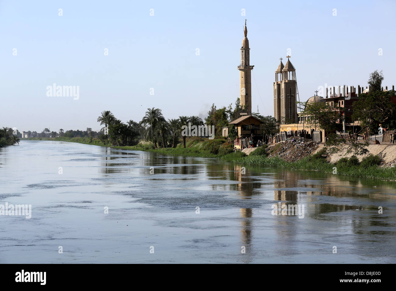 Una croce cristiana su una chiesa copta e cresent sul minareto della moschea musulmana in Alto Egitto Foto Stock