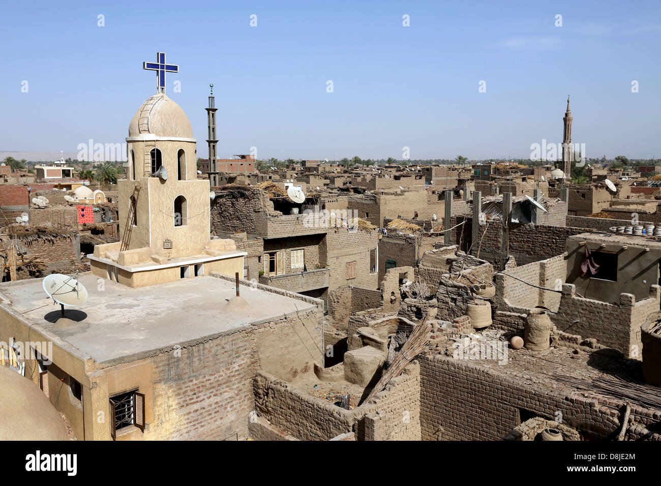 Una croce cristiana su una chiesa copta e cresent sul minareto della moschea musulmana in Alto Egitto Foto Stock