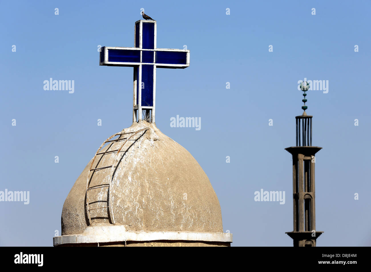 Una croce cristiana su una chiesa copta e cresent sul minareto della moschea musulmana in Alto Egitto Foto Stock