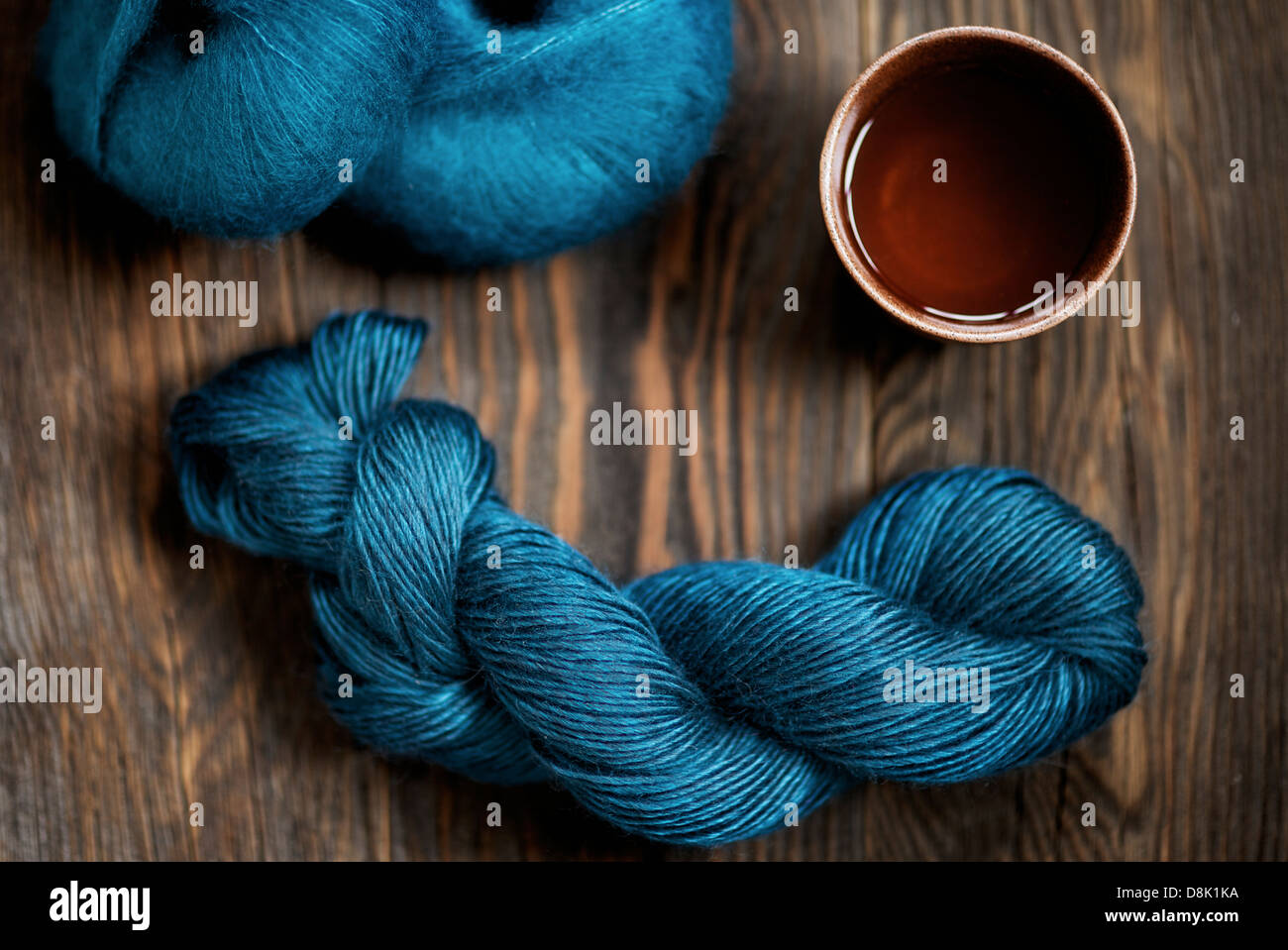 Bobine di teal lana merinos e lana Seta con una tazza di tè Foto Stock