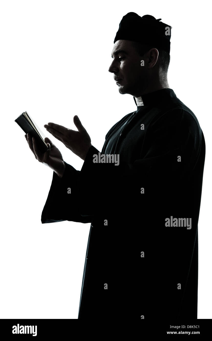 Un uomo caucasico sacerdote leggendo la Bibbia silhouette in studio isolato su sfondo bianco Foto Stock