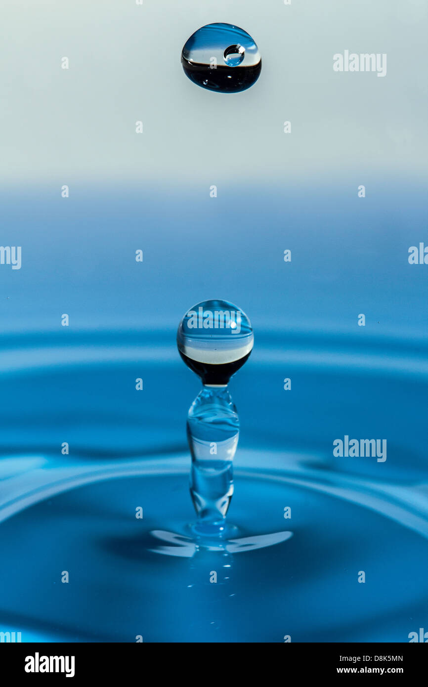 Caduta di acqua goccia con sfondo blu Foto Stock