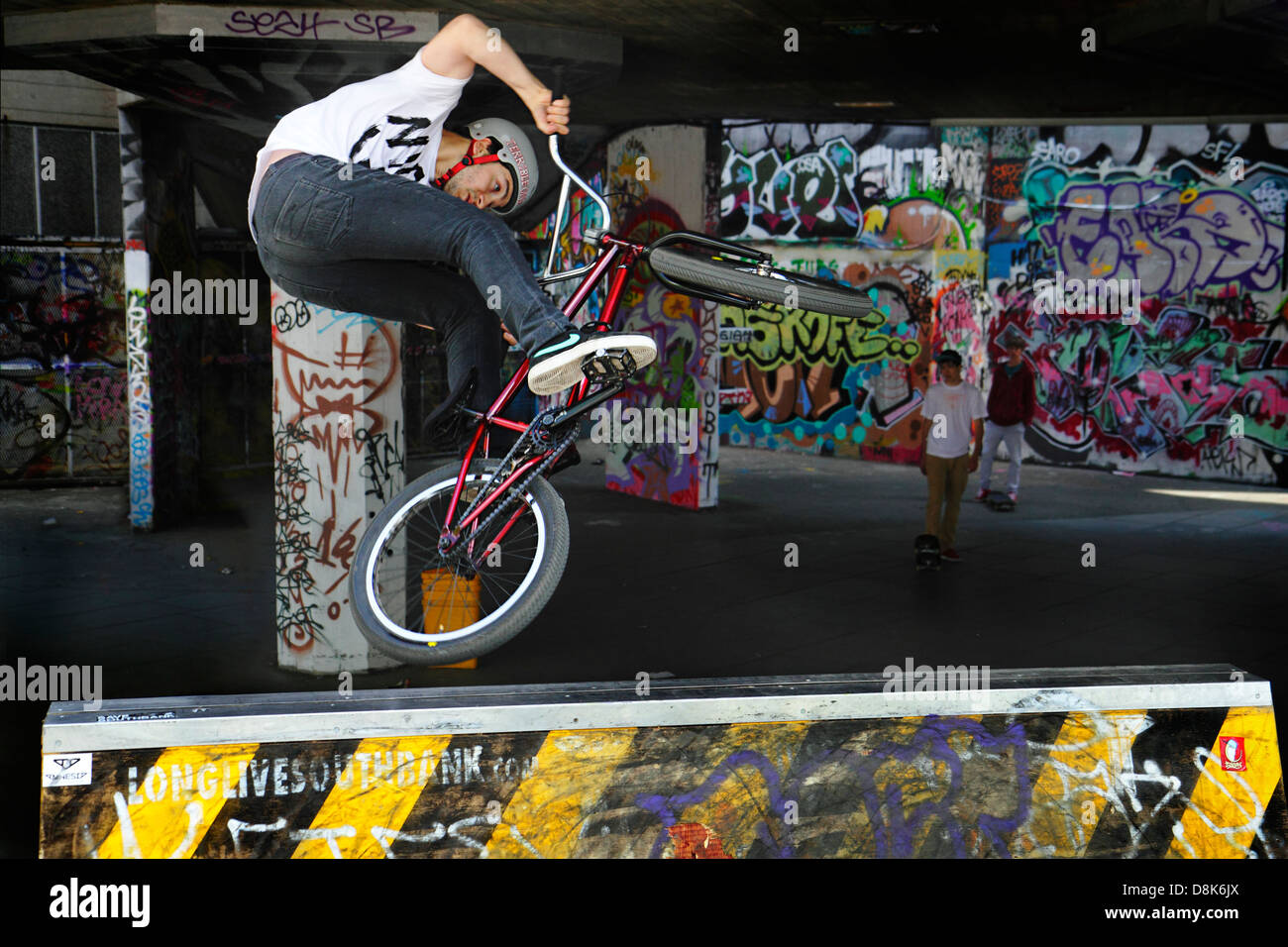 Una BMX rider esegue uno stunt al Southbank skateboard Park, London, Regno Unito Foto Stock