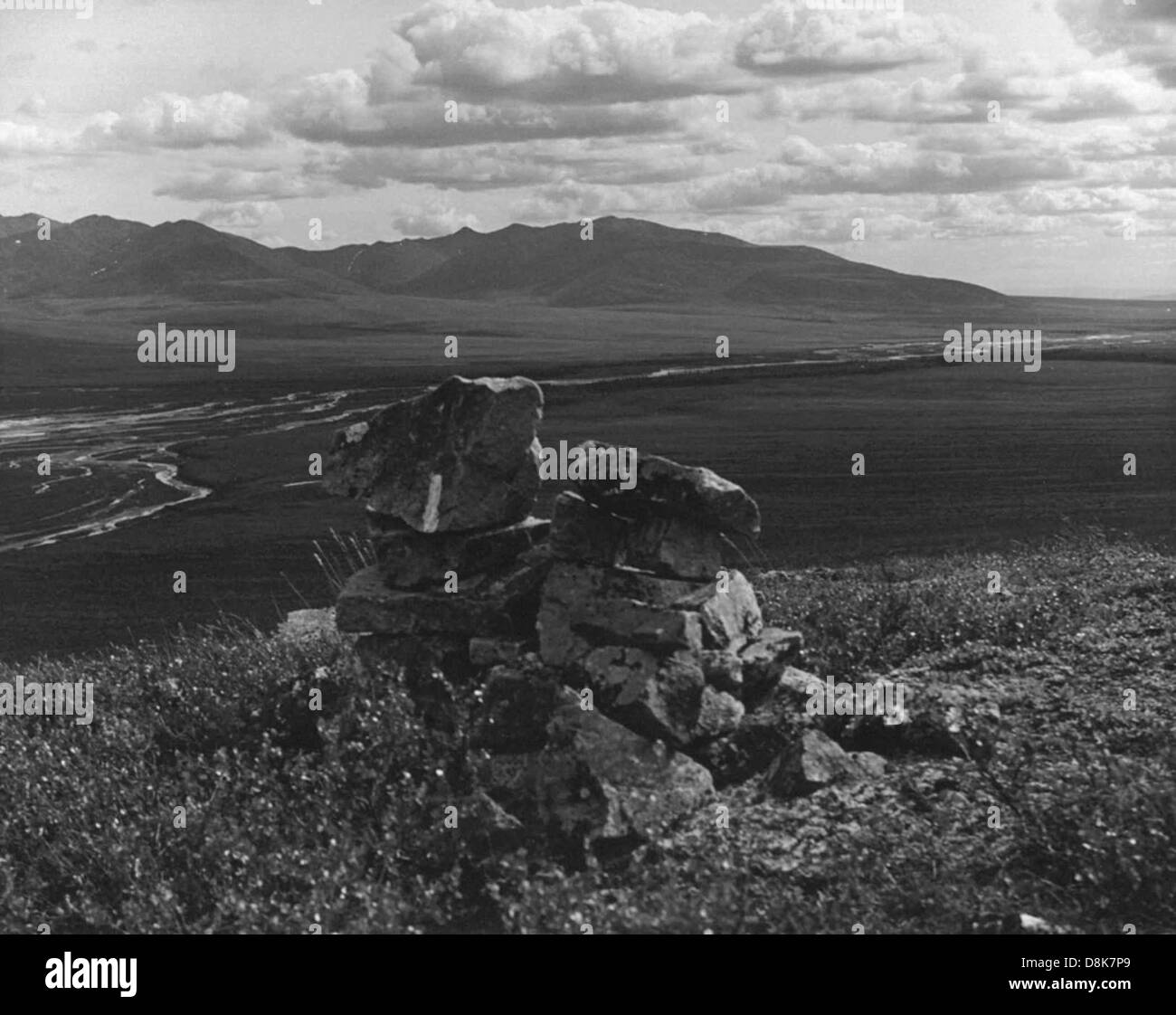 Un cairn di pietra, accuratamente impilato a mano, funge da simbolo o simbolo nel paesaggio naturale. I Cairns sono spesso utilizzati da escursionisti o viaggiatori per indicare un sentiero o fornire indicazioni in ambienti esterni, specialmente in zone montuose o remote. Foto Stock