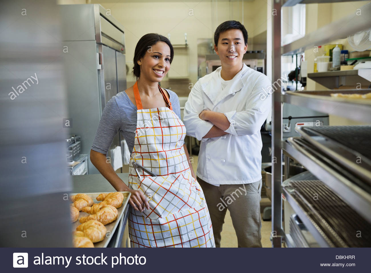Il bakers sorridente in piedi in forno Foto Stock