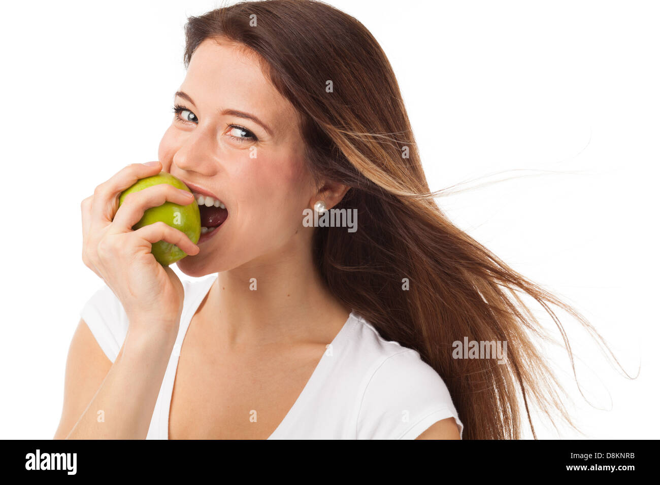 Giovane donna di mordere una mela verde, isolato su bianco Foto Stock