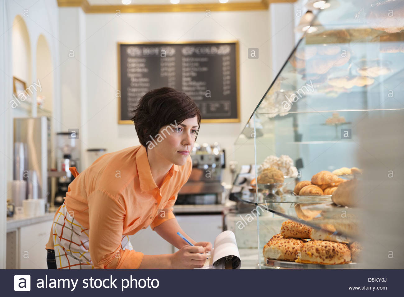 Femmina proprietario di piccola impresa, inventario in coffee shop Foto Stock