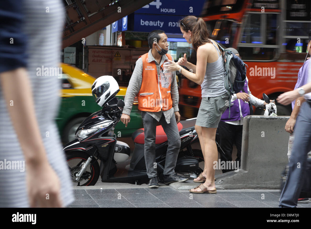 I turisti stranieri a parlare con Thai motociclo taxi su Silom Road di Bangkok , Thailandia Foto Stock