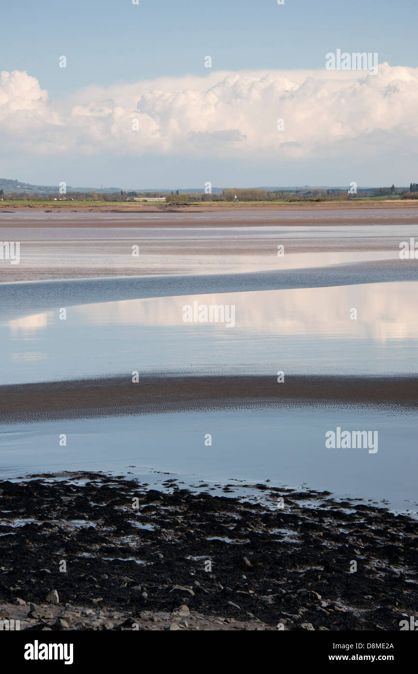 Fiume Severn, le misure di difesa contro le inondazioni, pietre, massi, banca, fango, lichen, skyscape, cielo blu, bianco e grigio nuvole Foto Stock