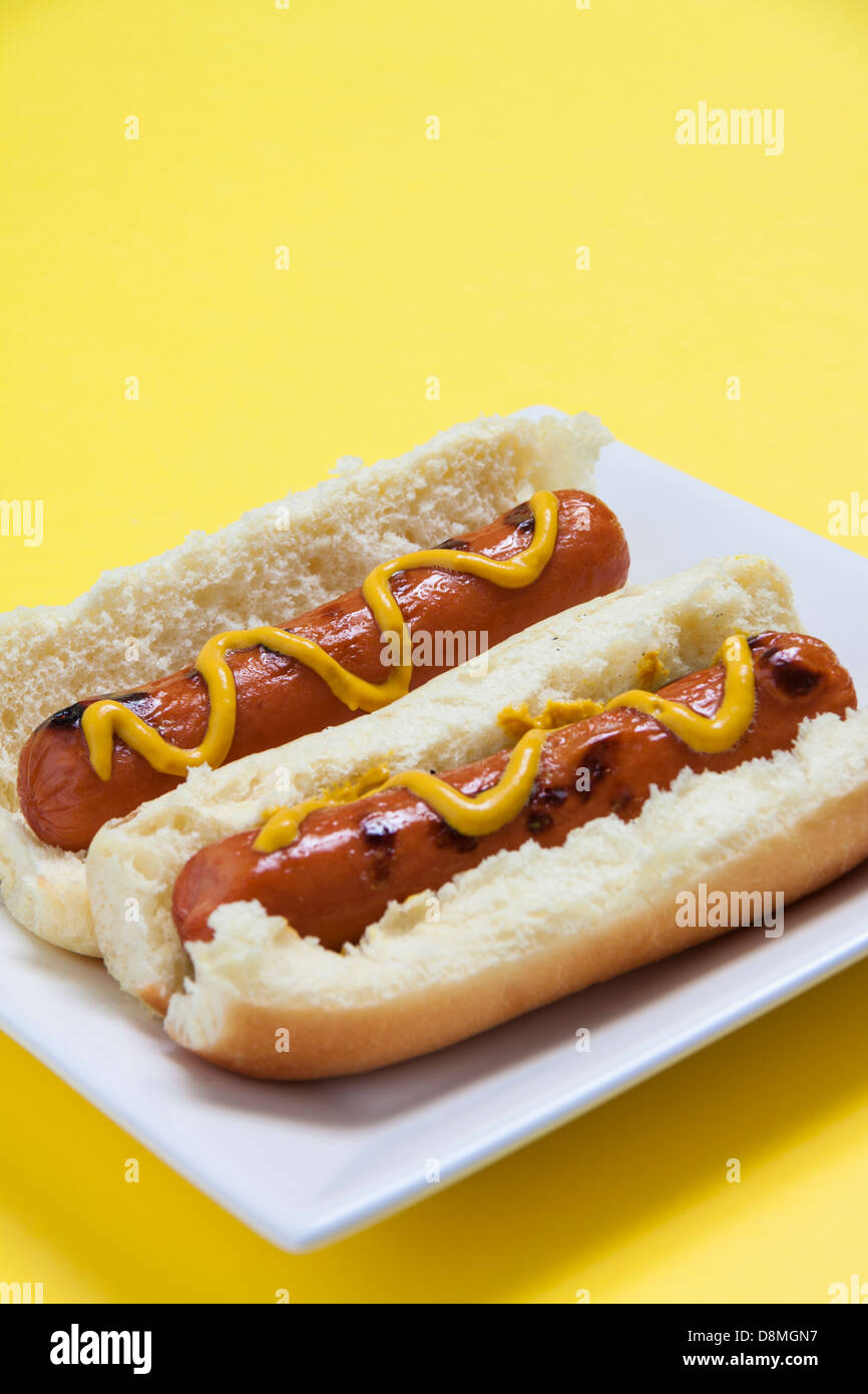 Due hot dogs isolato su sfondo giallo, verticale Foto Stock