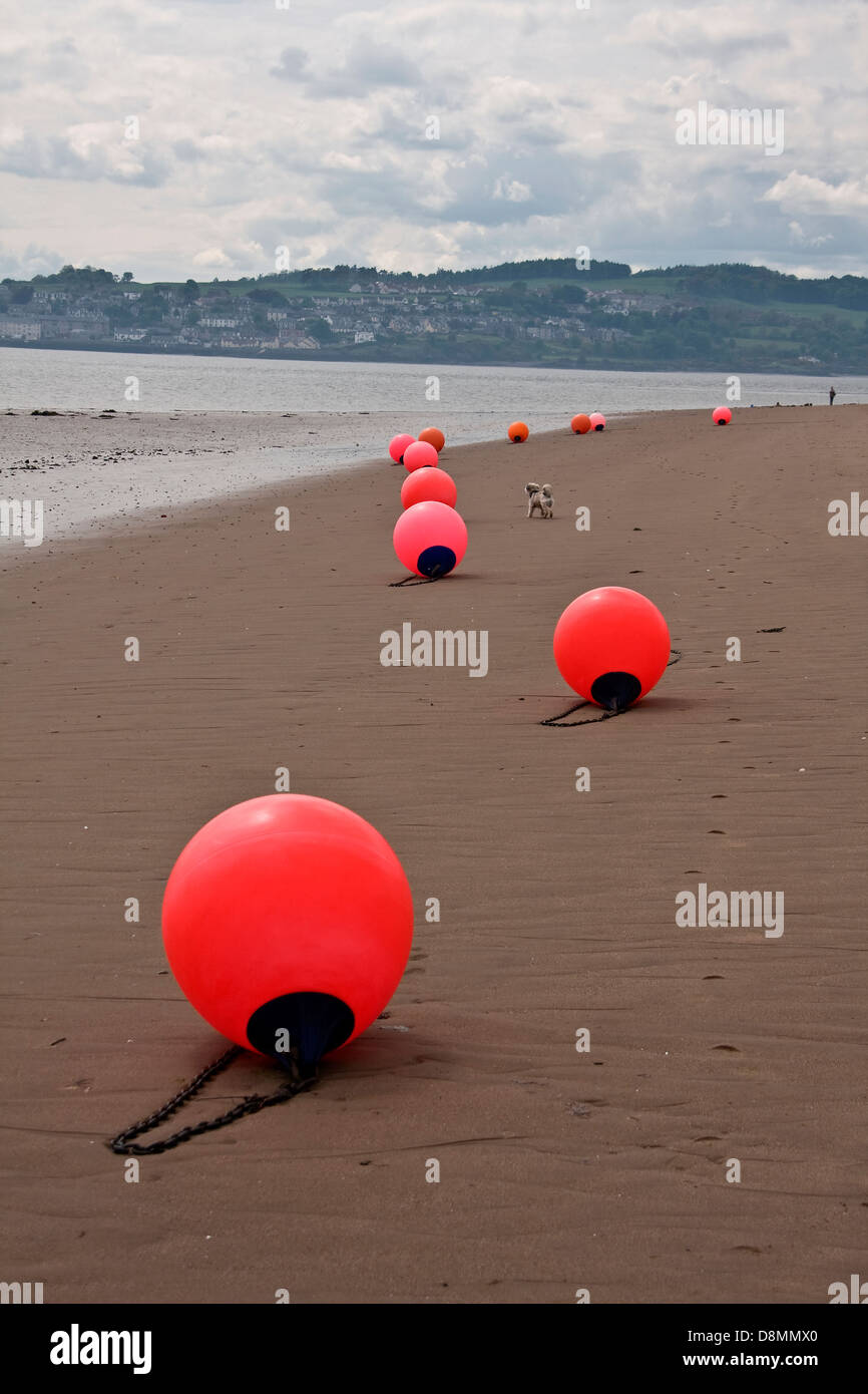 Bassa marea a Broughty Ferry Beach che mostra una fila di boe arancione allineati lungo il fiume Tay costa vicino a Dundee, Regno Unito Foto Stock