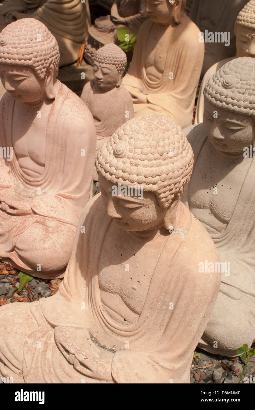 Il Buddha figurines sono schierate per la vendita in corrispondenza di un bordo strada business. Foto Stock