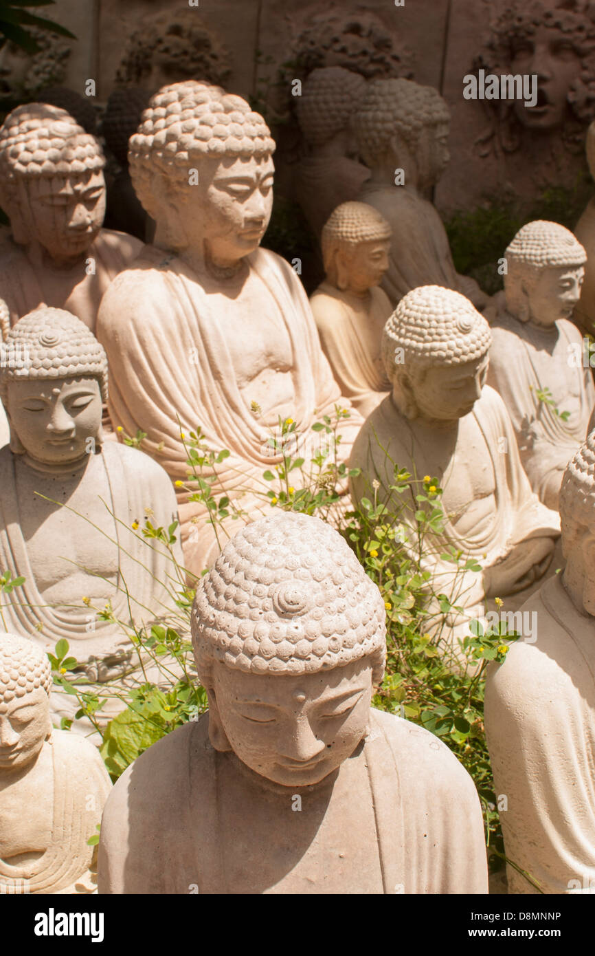 Il Buddha figurines sono schierate per la vendita in corrispondenza di un bordo strada business. Foto Stock