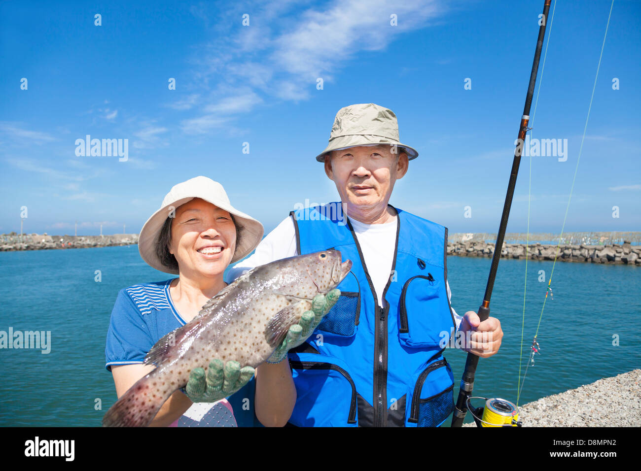Felice coppia senior andare a pescare e mostrando grande pesce Foto Stock