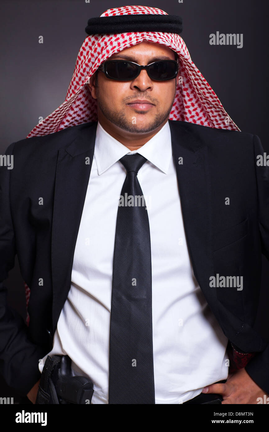 Bodyguard islamica con una pistola contro la massa nero Foto Stock