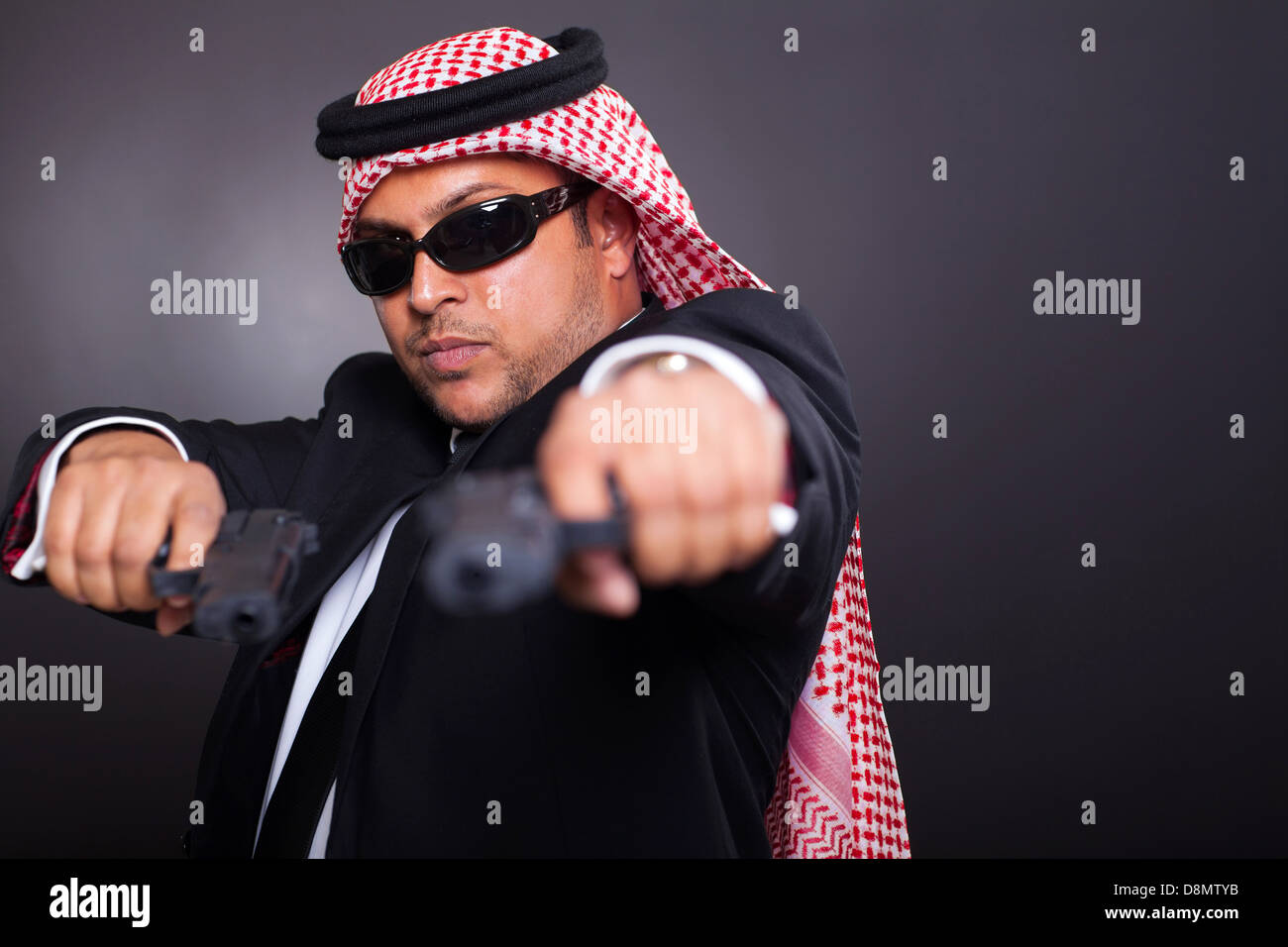 In Medio Oriente la guardia del corpo in posa con pistole su sfondo nero Foto Stock