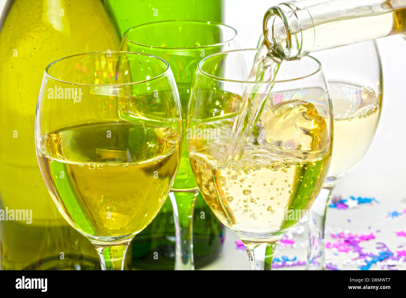 Vino bianco versando in bicchieri - vino bianco che viene versato in bicchieri a parte. Foto Stock