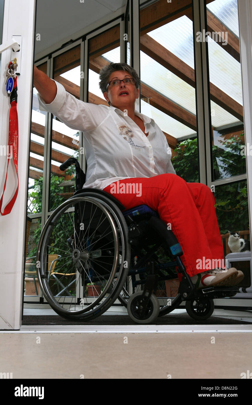 Una donna su una sedia a rotelle Foto Stock