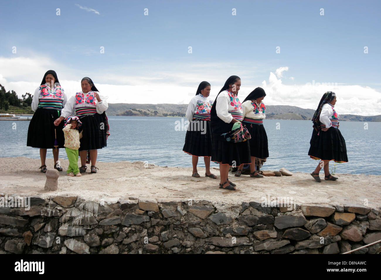 Persone locali riuniti i turisti sul molo di Isola Amantani, il lago Titicaca, Perù, Sud America Foto Stock