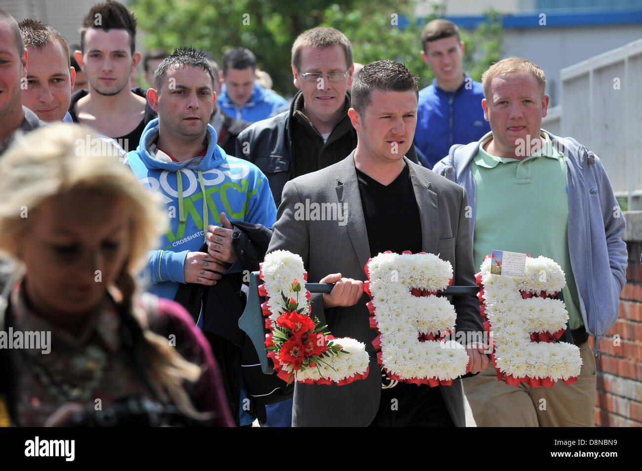 LUTON, Regno Unito. Il 1 giugno 2013. La Difesa inglese League tenere una silenziosa passeggiata nel memoriale del soldato Lee Rigby che fu ucciso a Woolwich il mese scorso. I leader dell'EDL Tommy Robinson (vero nome Stephen Yaxley-Lennon, raffigurato holding omaggio floreale) e Kevin Carroll condurre una passeggiata attraverso la città al memoriale di guerra al di fuori del municipio. Credito: Polly Thomas / Alamy Live News Foto Stock