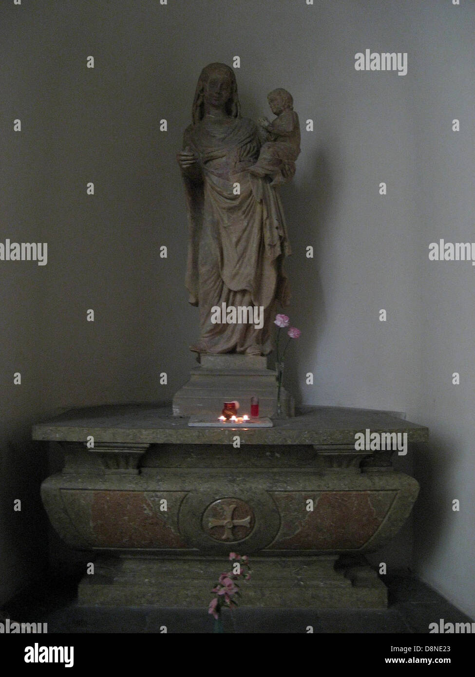 Questa immagine presenta una statua della Vergine Maria, tipicamente raffigurata in una posa serena e delicata. La statua è un'icona religiosa comune che rappresenta la madre di Gesù Cristo, spesso trovata in chiese, giardini e spazi religiosi. Foto Stock