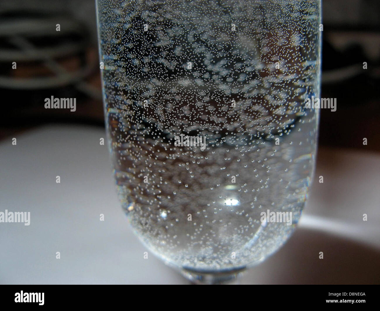 Bolle d'acqua sospese all'interno di un bicchiere, creando un interessante effetto visivo. Le bolle si formano a causa dell'aria o del gas intrappolati nel liquido, spesso visto nelle bevande gassate o quando l'acqua viene versata da un'altezza elevata. Foto Stock